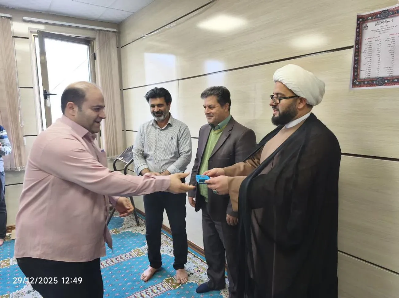 مدیر ستاد اقامه نماز لرستان در حال اهدای لوح تقدیر به یکی از کارکنان اداره گاز خرمآباد