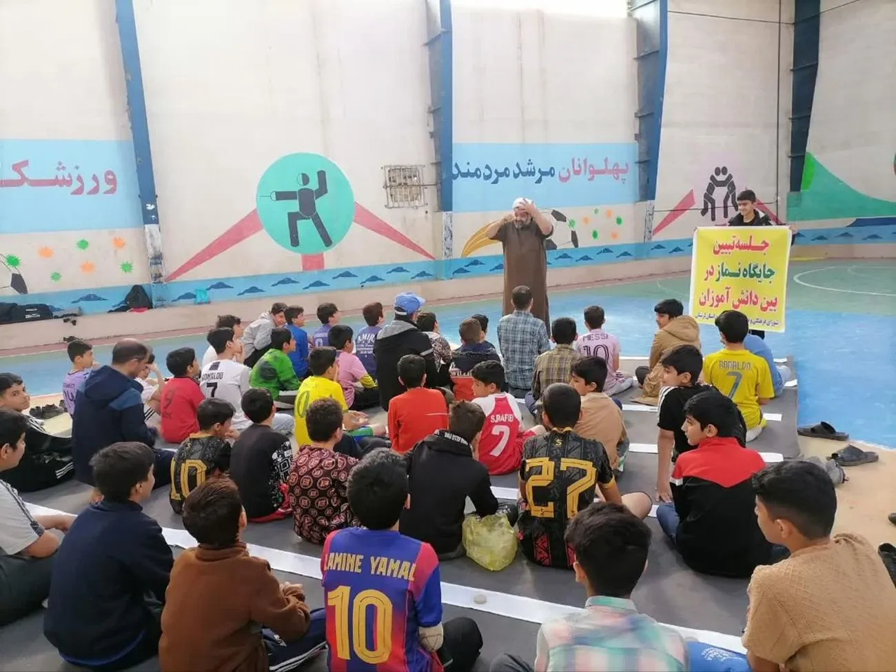 تصویری از اقامه نماز جماعت فرزندان کارکنان توزیع برق لرستان در کنار زمین فوتسال