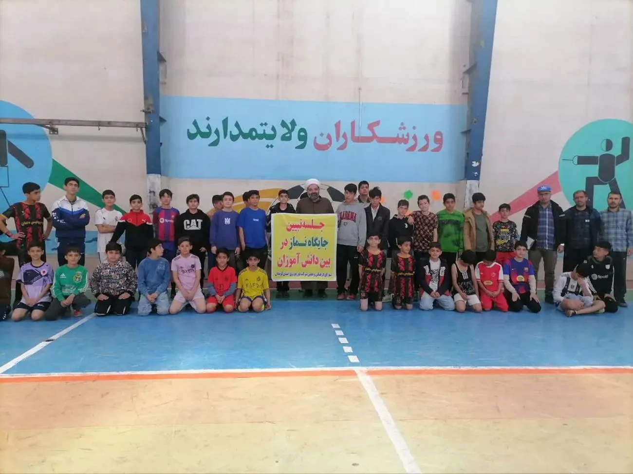 تصویری از اقامه نماز جماعت فرزندان کارکنان توزیع برق لرستان در کنار زمین فوتسال